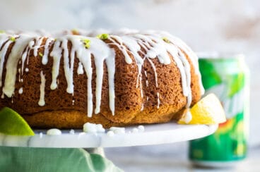 A 7up cake on a marble cake stand.