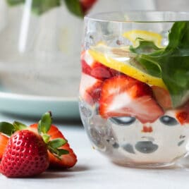 Glasses of water infused with fruit, vegetables, and fresh herbs.