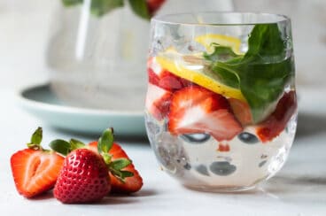 Glasses of water infused with fruit, vegetables, and fresh herbs.
