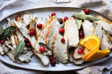 Slices of air fryer turkey on an oval platter.