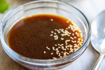 A bowl of Asian Salad Dressing sitting in front of a bowl of Chinese Chicken Salad.