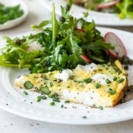 Asparagus frittata on a white plate with a salad.