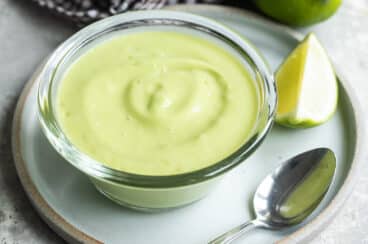 A small bowl of avocado sauce on a plate.