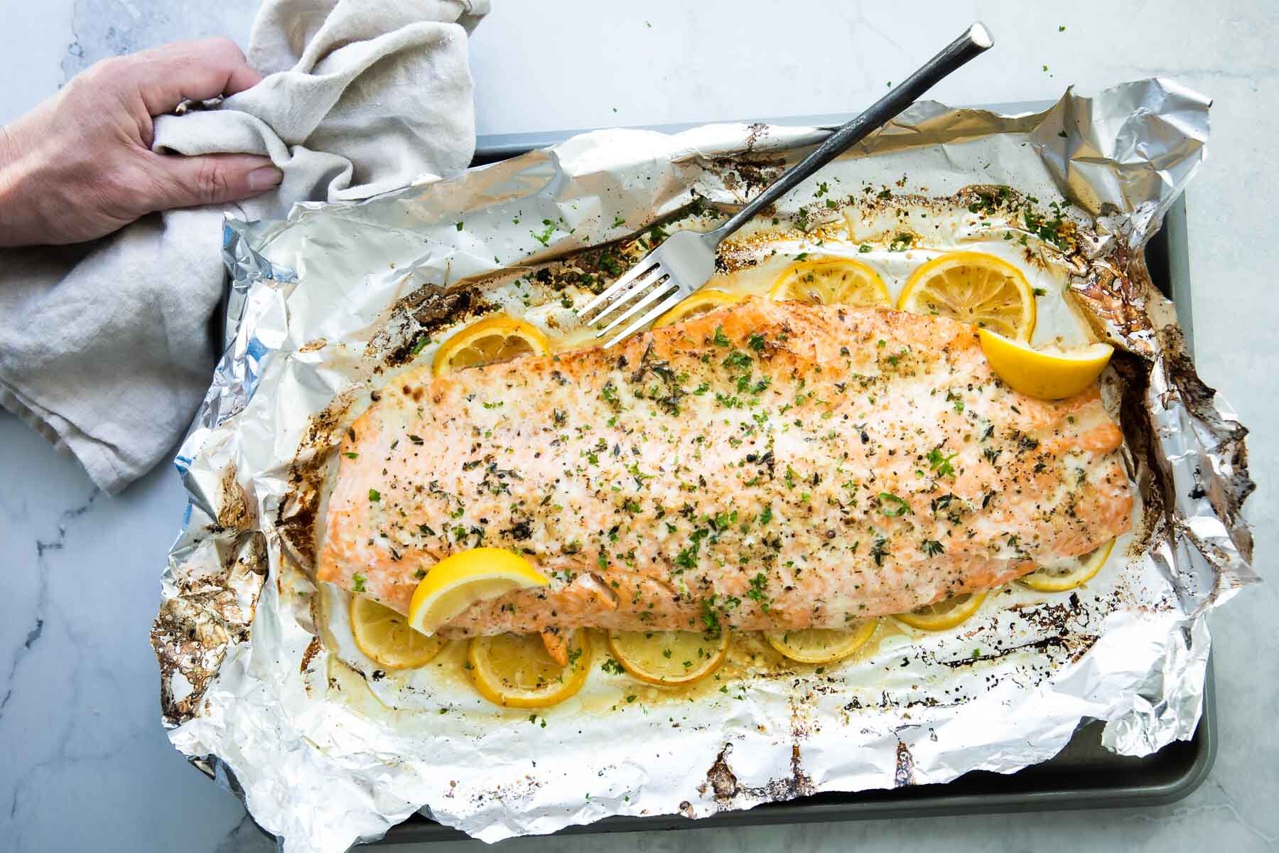 Baked salmon on a foil lined baking sheet after being baked,