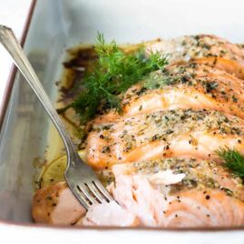Salmon filets in a white baking dish after being baked.