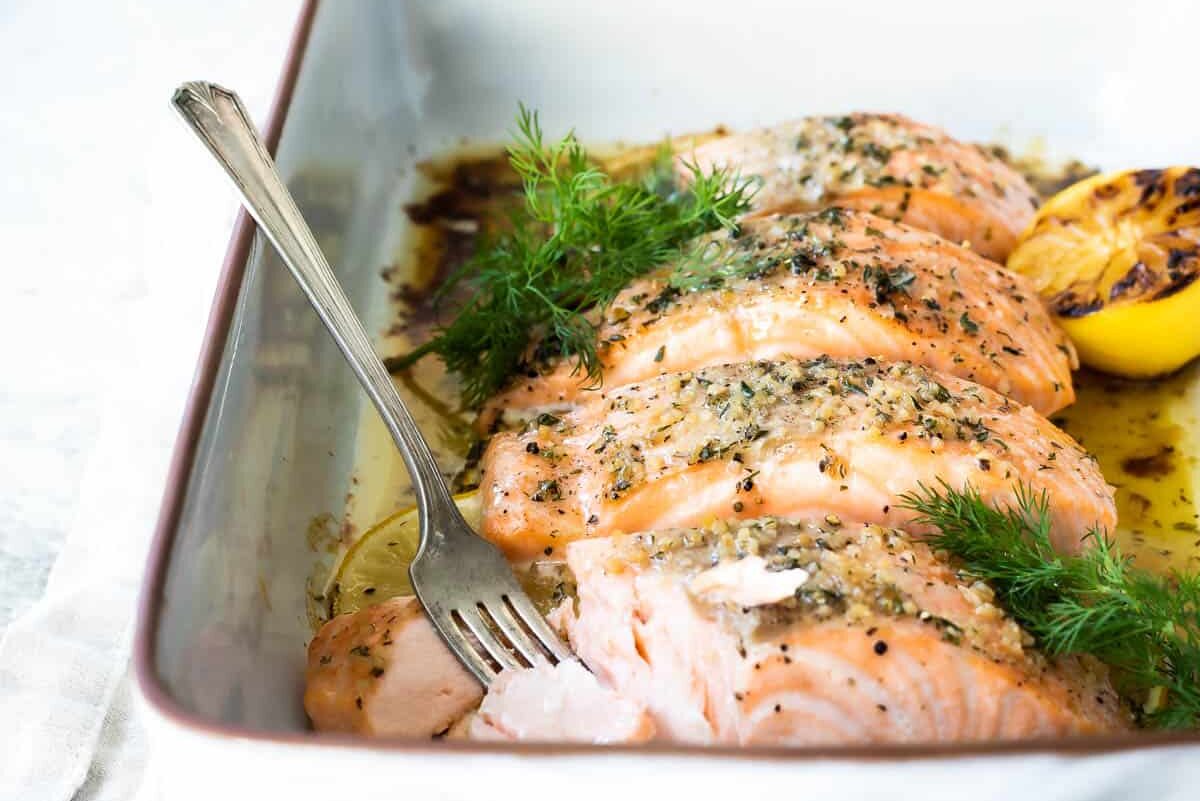 Salmon filets in a white baking dish after being baked.