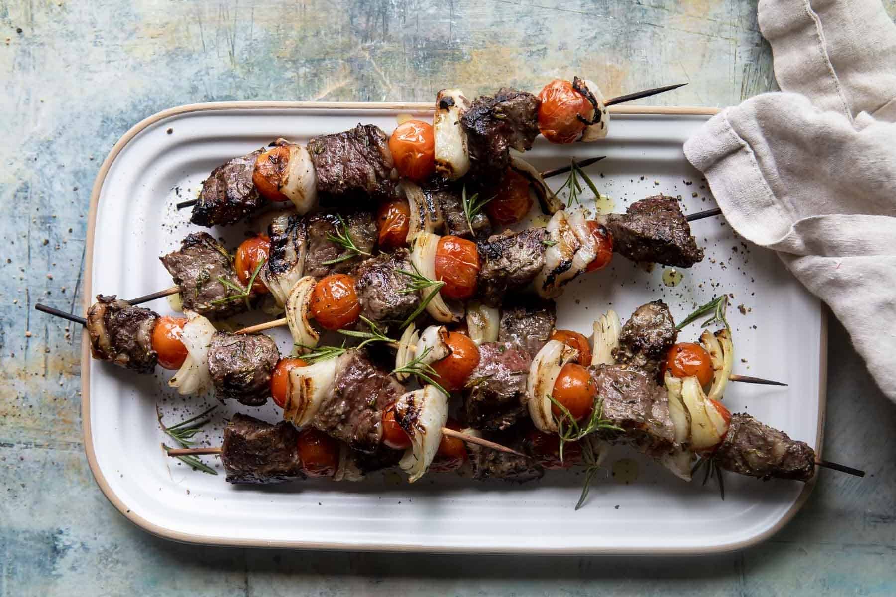 A platter full of beef kabobs.