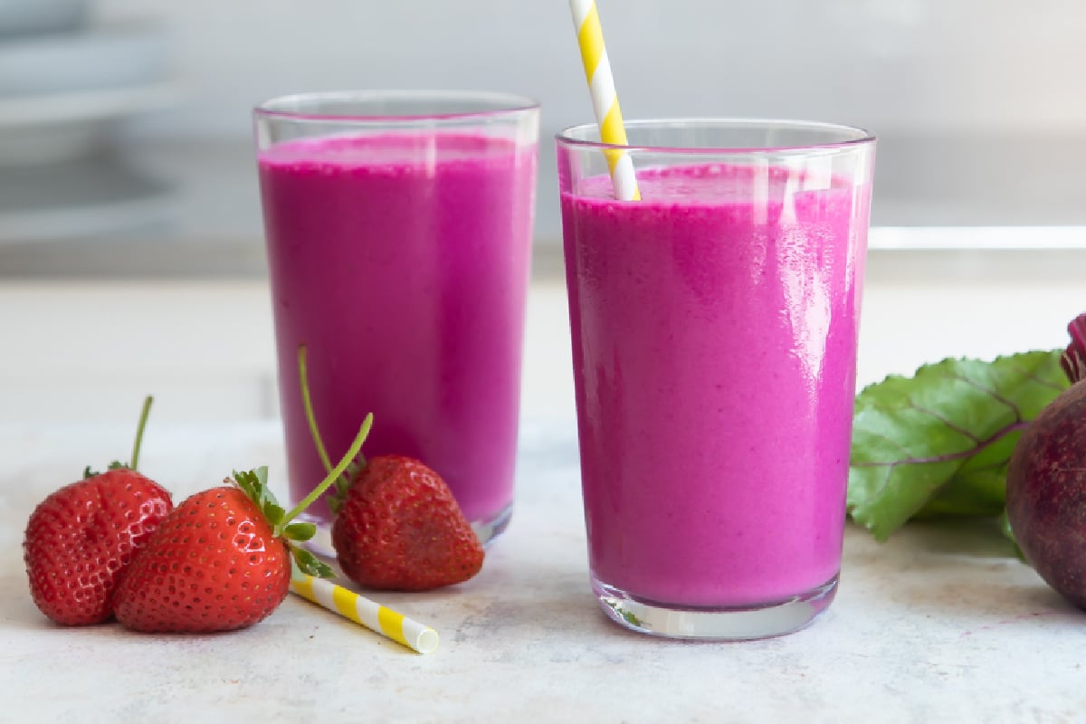 2 glasses of beet smoothie with straws.