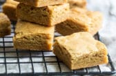 A stack of blondies on a cooling rack.