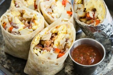 Breakfast burritos cut in half on a sliver tray.