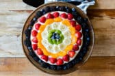 A brownie pizza on a wooden platter.