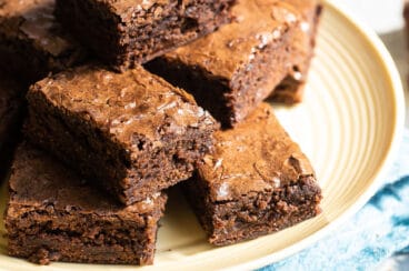 Brownie squares on a yellow circle plate.