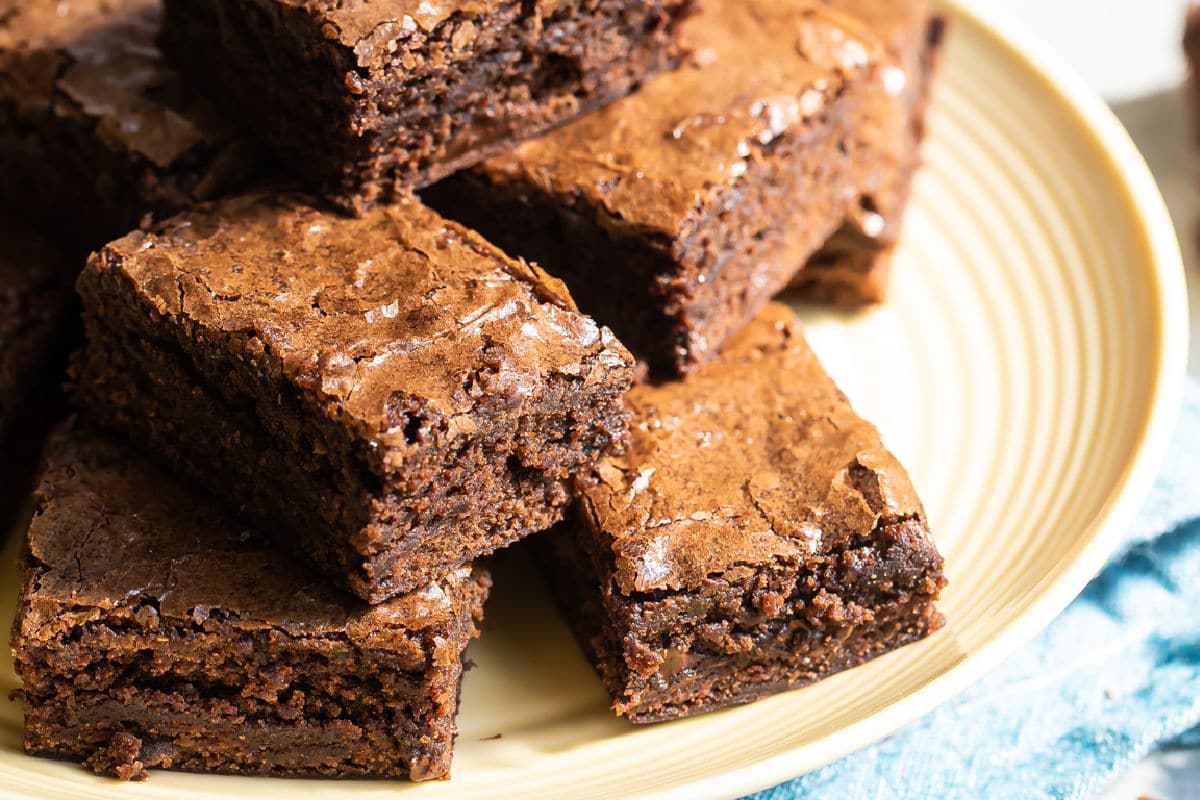 Brownie squares on a yellow circle plate.