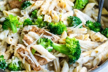 Cajun chicken alfredo with broccoli in a silver skillet.