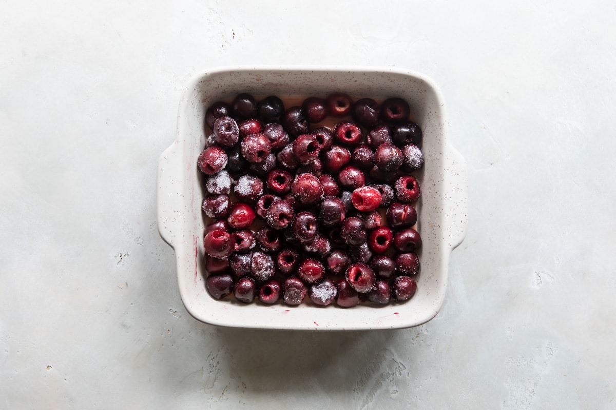 Cherries and orange juice in a baking dish for cobbler.