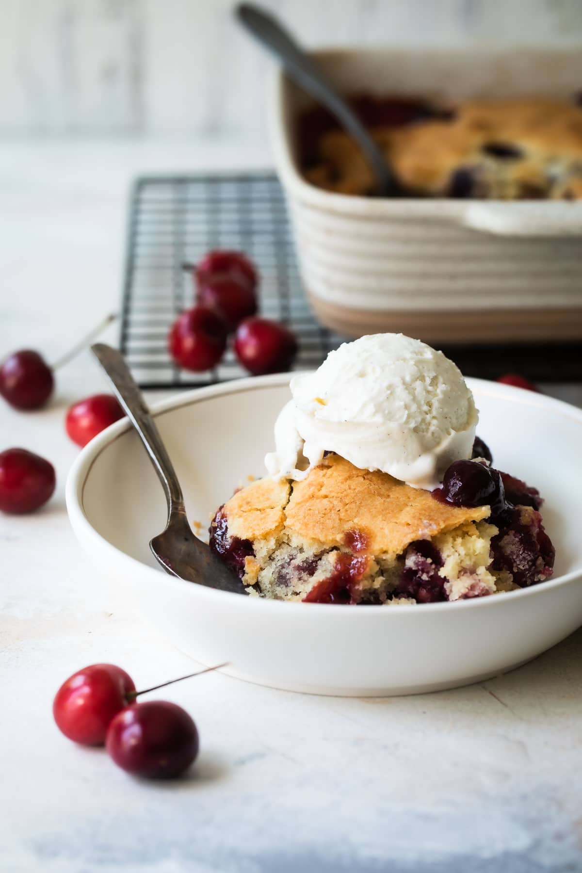 Two plates of blueberry cobbler with ice cream.