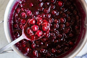 Cooking cherry pie filling in a large stock pot.