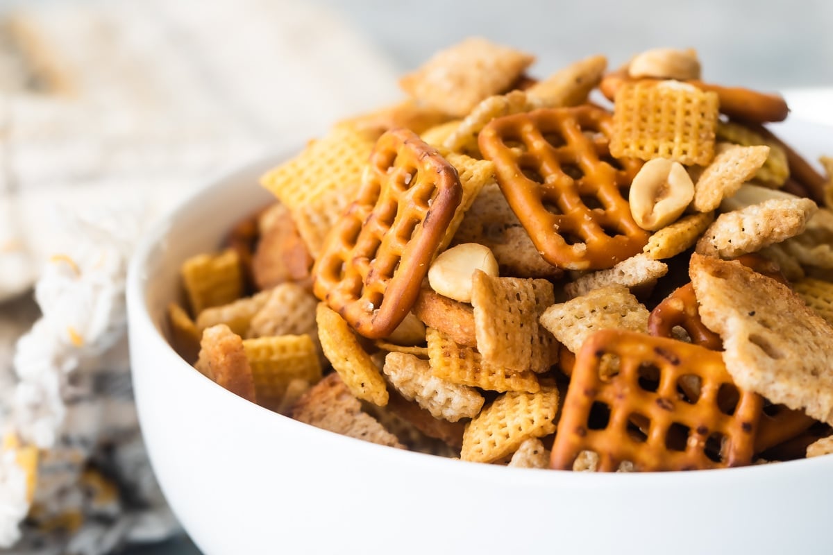 A bowl of Chex mix on a gray background.
