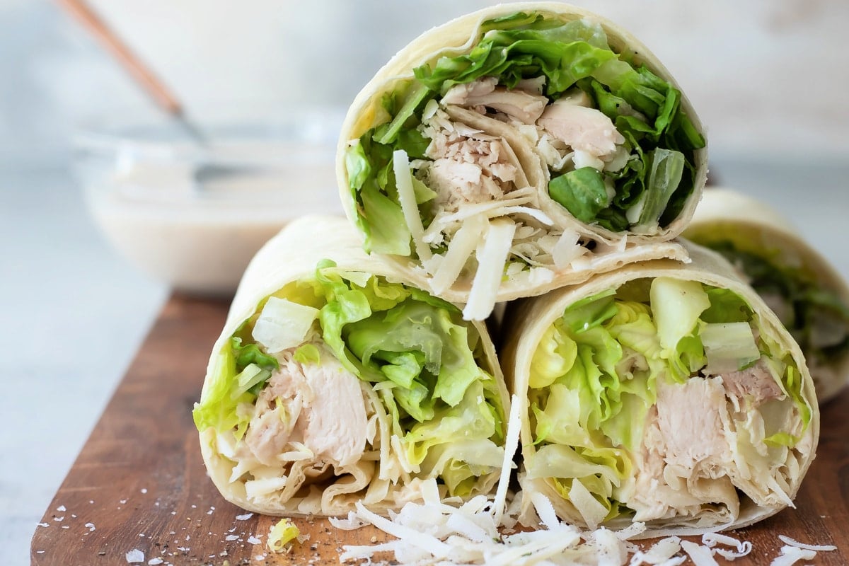 A board full of Chicken Caesar Wraps sliced in half.