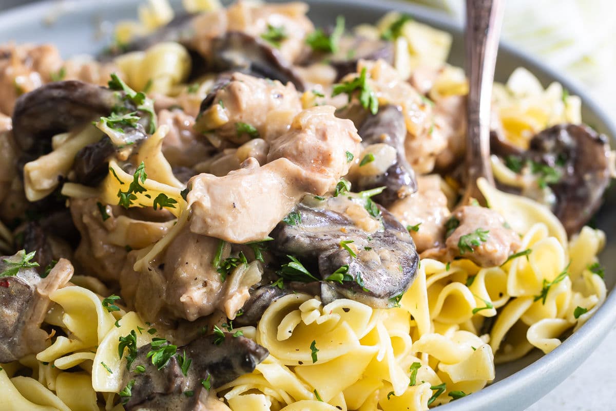 Chicken and mushroom stroganoff in a blue bowl.