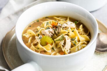 Chicken noodle soup in a white bowl.