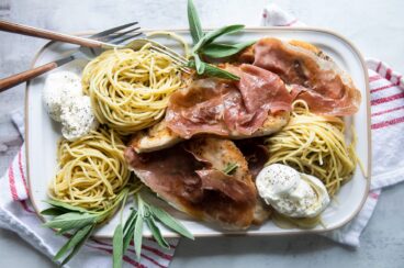 Chicken Saltimbocca on a white rectangular platter.