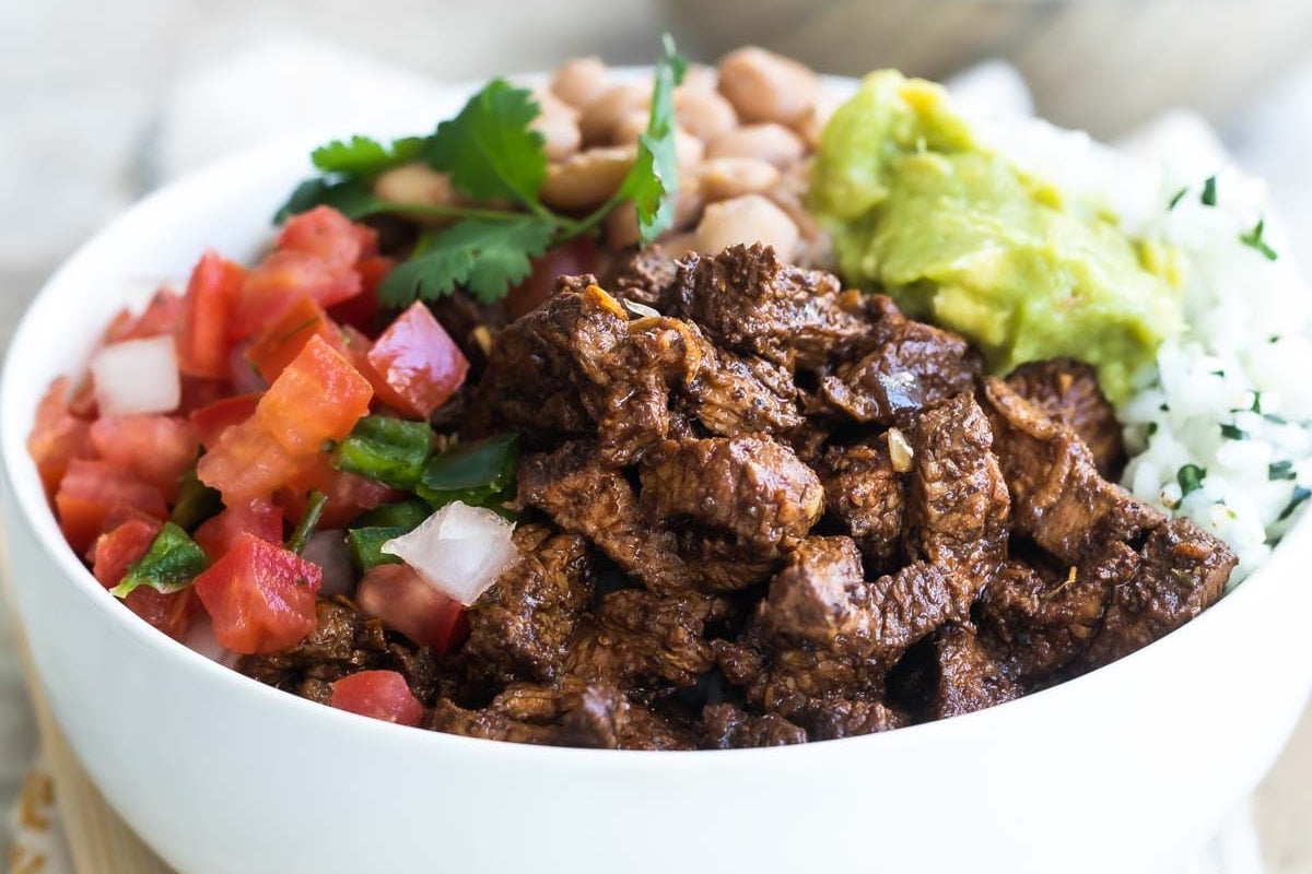 A bowl of Chipotle steak, pinto beans, cilantro-lime rice, and pico de gallo.