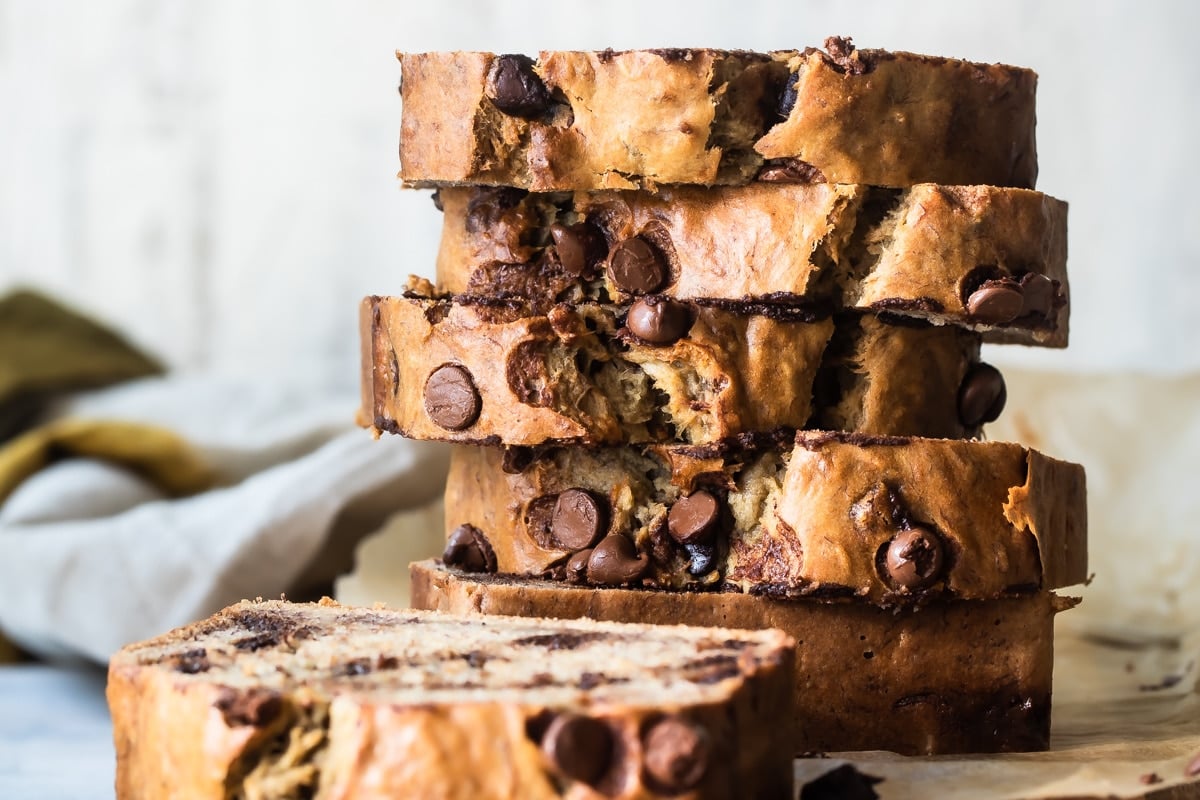 Thick slices of chocolate chip banana bread on a wooden cutting board.