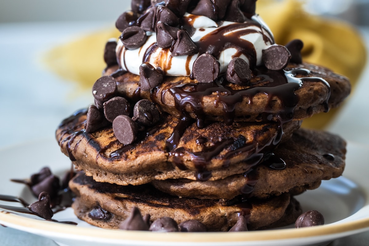 A stack of chocolate pancakes on a plate.