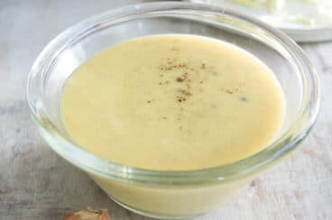 Coleslaw dressing in a clear bowl on a countertop.