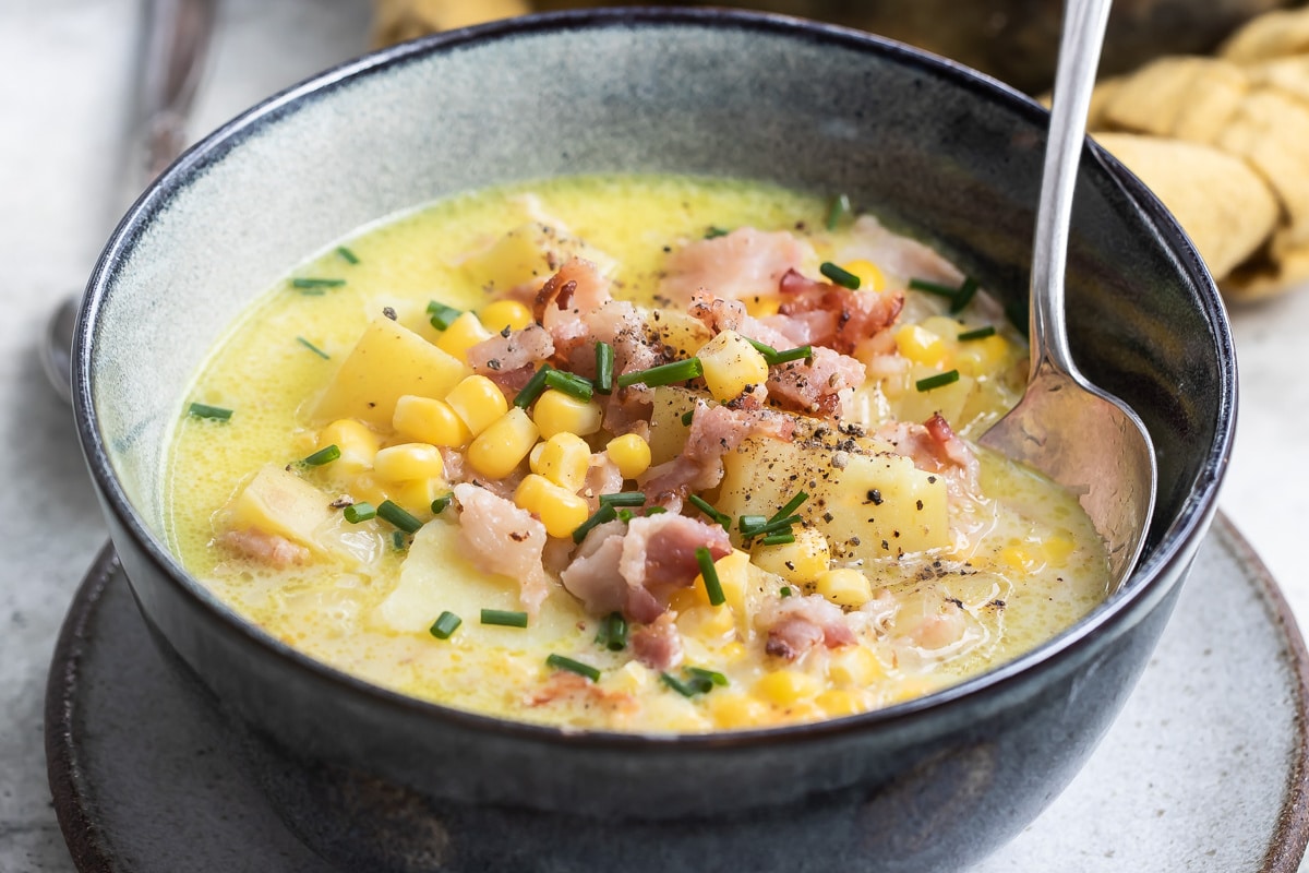 Corn chowder in a dark gray bowl.