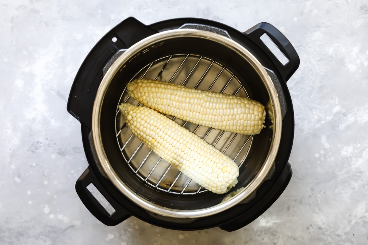 2 ears of corn in the bottom of an Instant Pot.