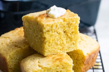 Four pieces of cornbread on a cooling rack.