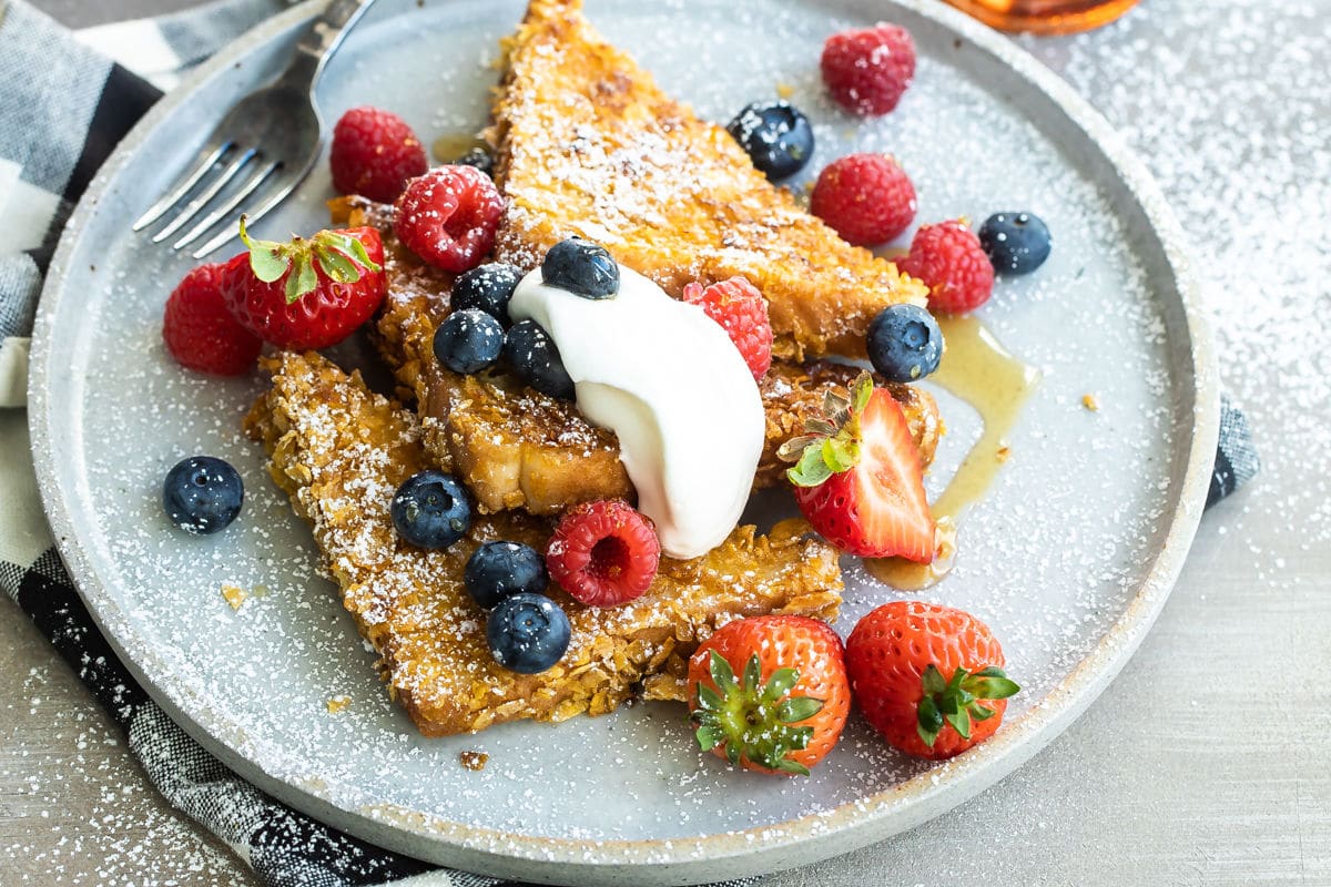 A plate of cornflake crusted french toast with fruit.