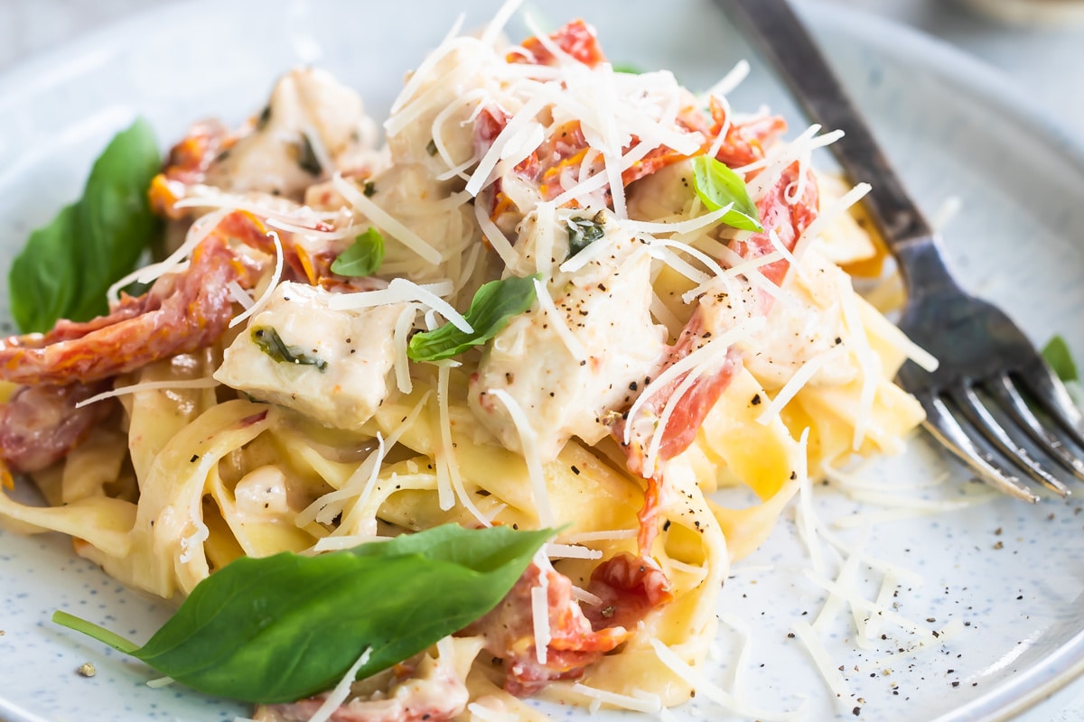 Two plates of creamy chicken pasta.