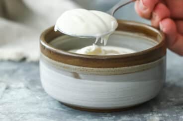 Creme Fraiche being spooned out of a small bowl.