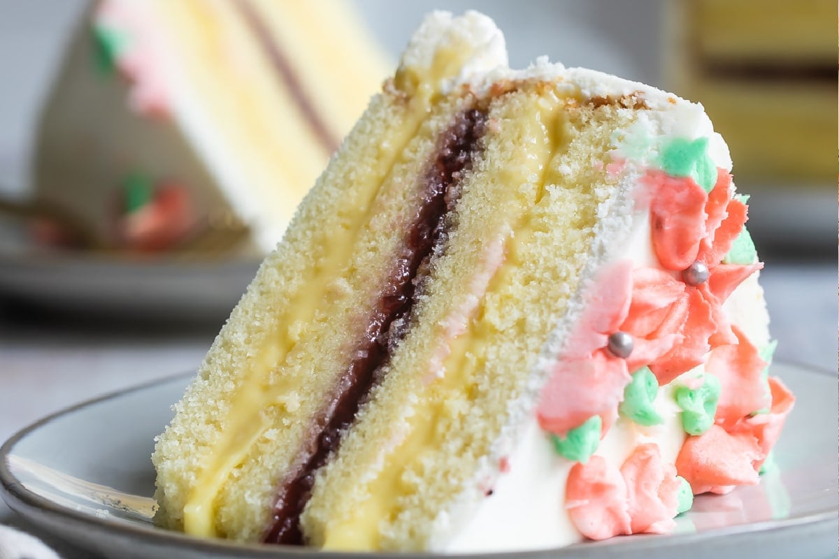 A slice of Danish Layer cake on a small gray plate.