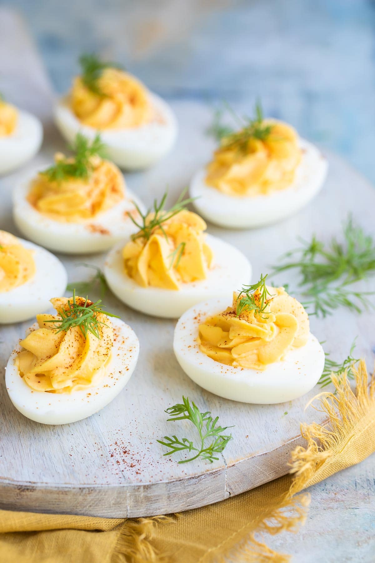 Deviled eggs on a round wooden platter.