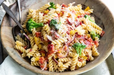 Easy cold pasta salad in a wooden bowl with a serving fork and spoon.
