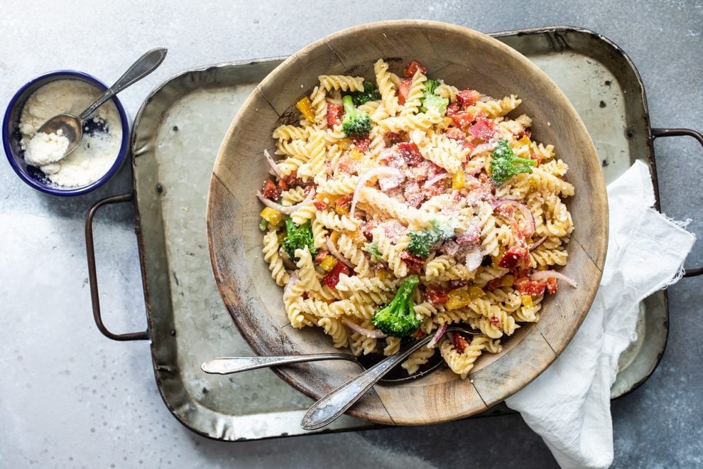 Easy cold pasta salad in a wooden bowl with a serving fork and spoon.