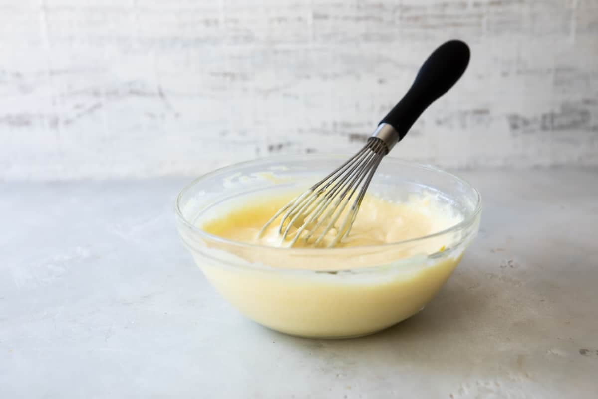 Dressing for easy potato salad in a clear bowl.