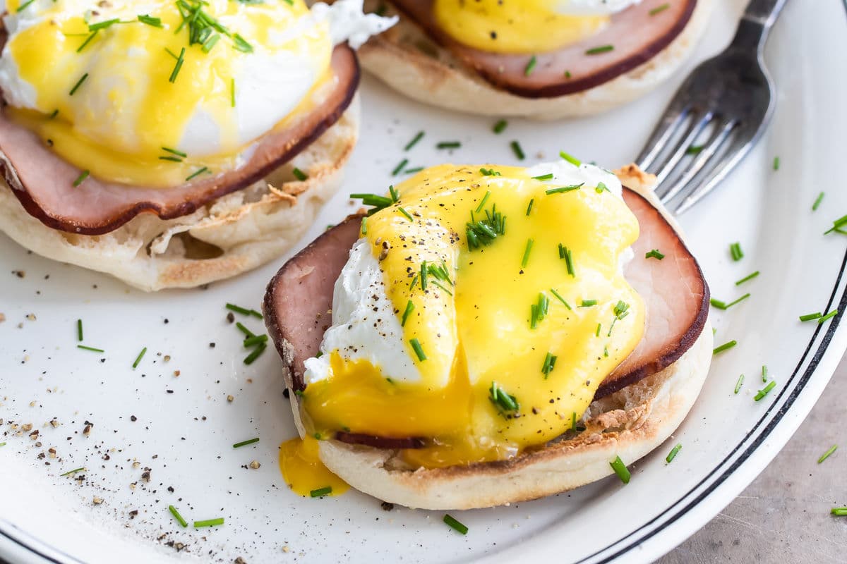 Eggs benedict on a white plate.