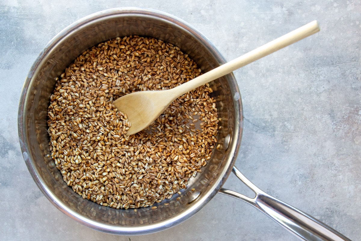 Toasting farro in a saucepan.