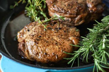 Two filets in a teal skillet.