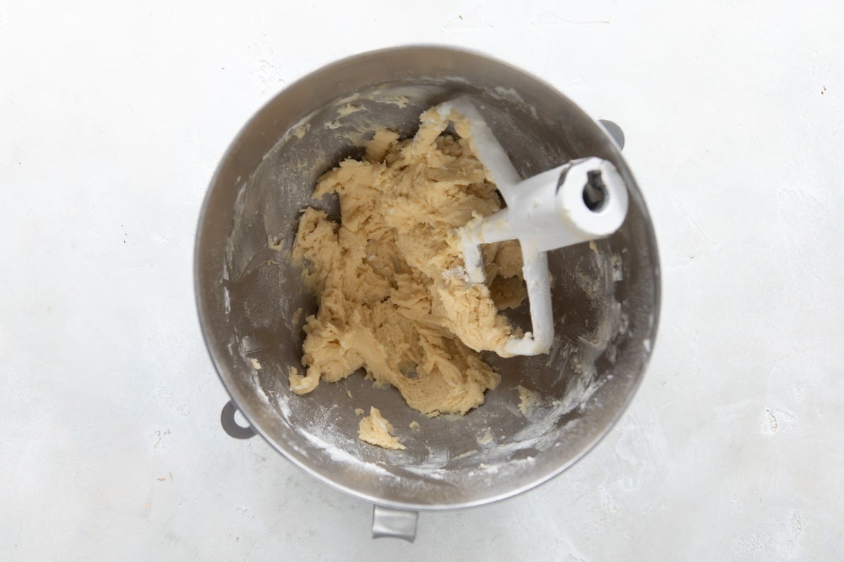 Tart dough in a silver mixing bowl with a beater.