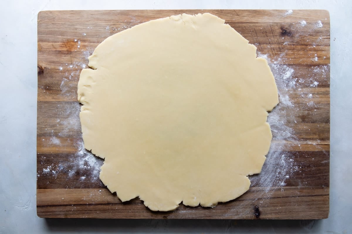 A tart crust on a wooden cutting board.