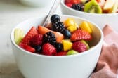 Fruit salad in a small white bowl.