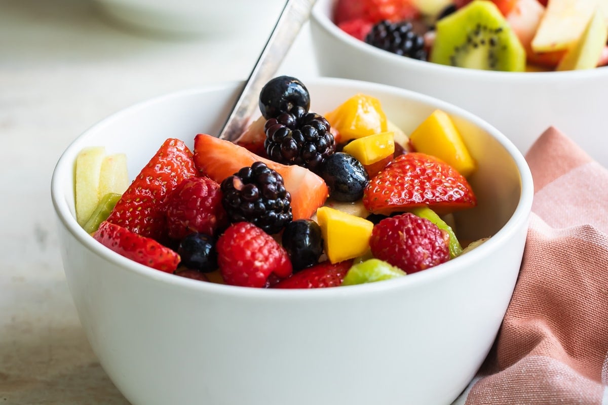 Fruit salad in a small white bowl.
