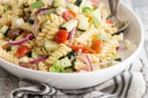 Greek pasta salad in a white bowl.