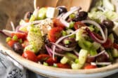 A Greek salad in a wooden bowl.
